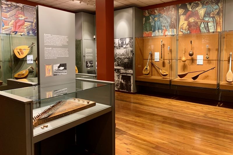 Greek stringed instruments displayed in cases in a museum gallery