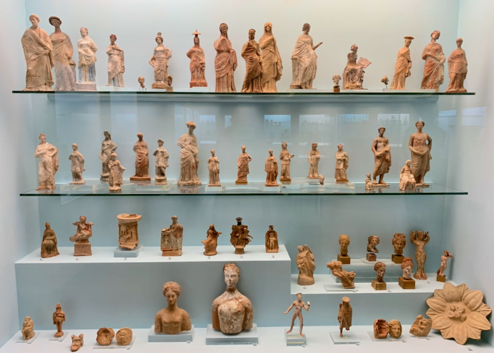 Clay human figurines in a museum display case