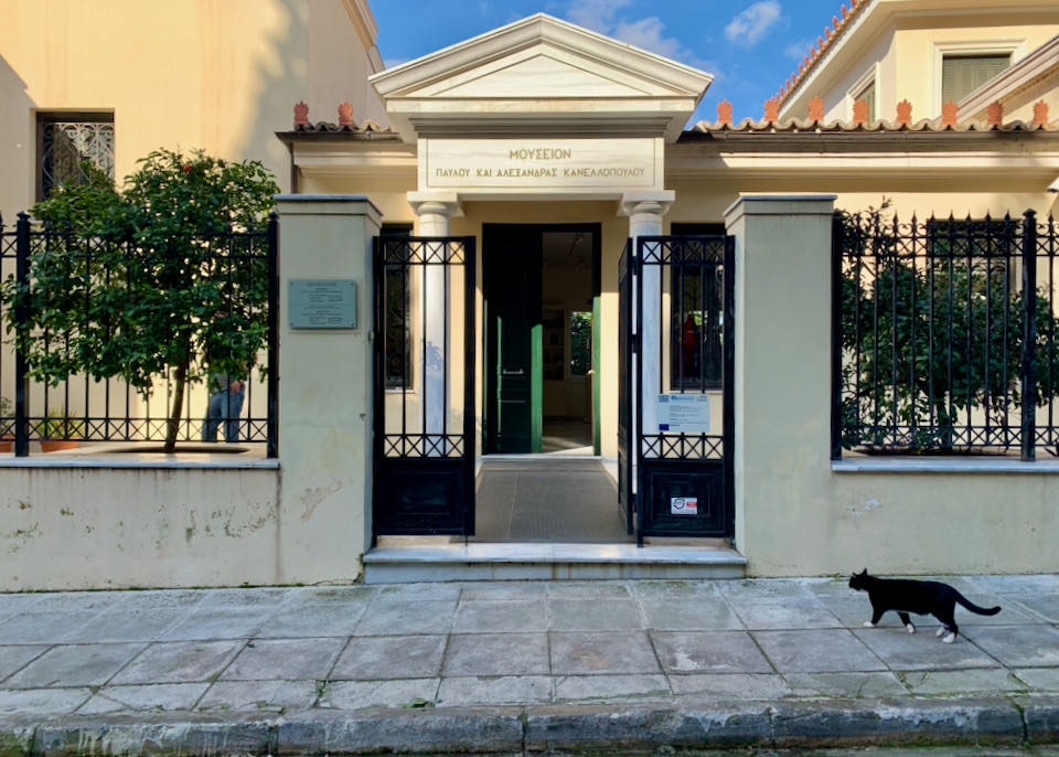 Entrance to a neoclassical building, with a cat in front