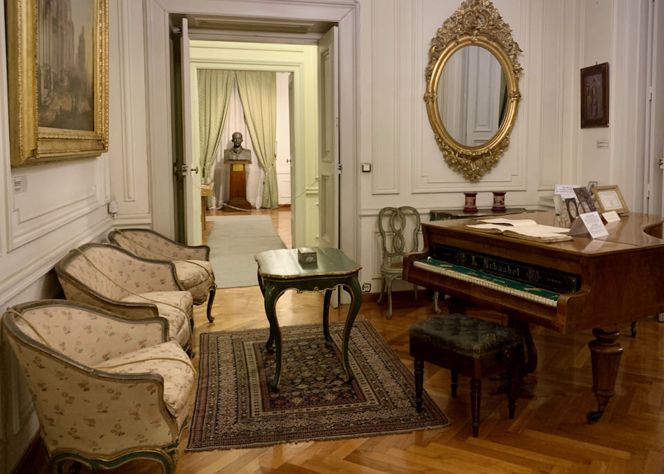 Room with a grand piano and two side chairs