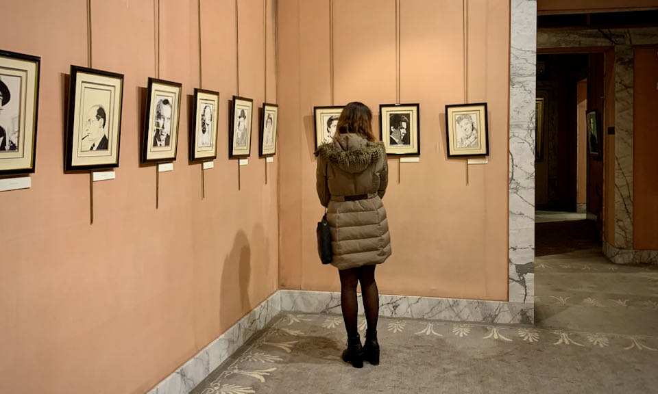 A woman looks at black and white photos hanging on a wall
