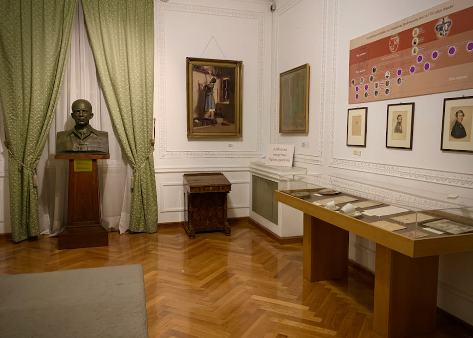 A room with statues, paintings, and papers on display