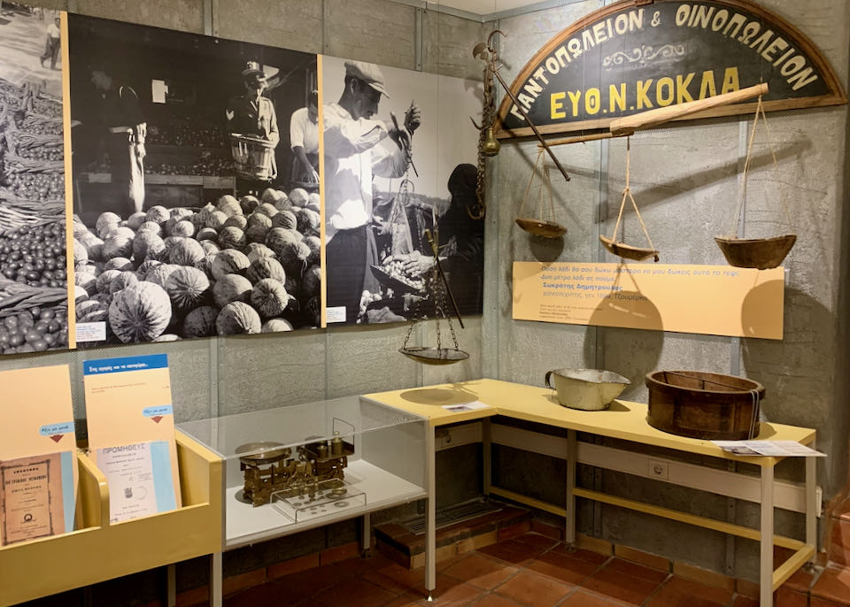Old scales displayed alongside a black and white photo of a winemaker using them to weigh grapes