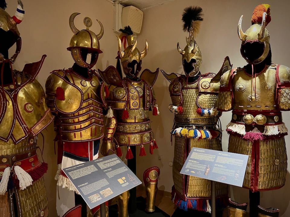 Brass suits of armor displayed together at a museum