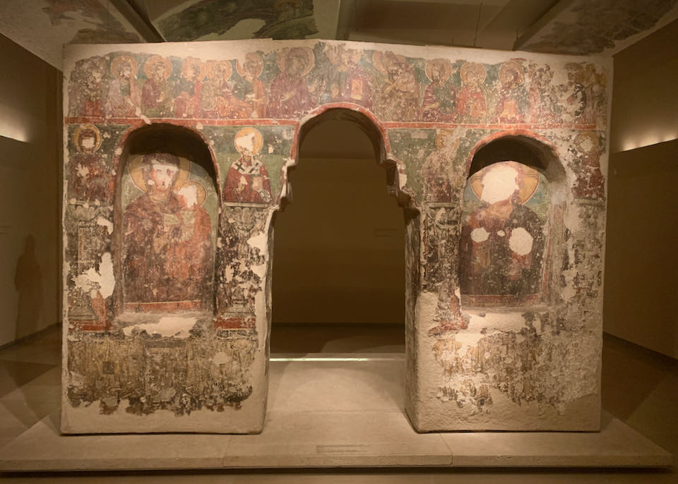 Museum display of a wall covered in religious frescoes