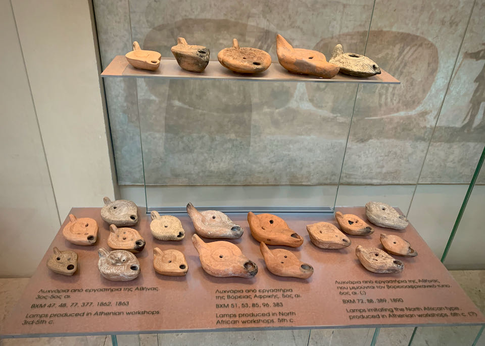 Ancient clay oil lamps displayed in a museum case