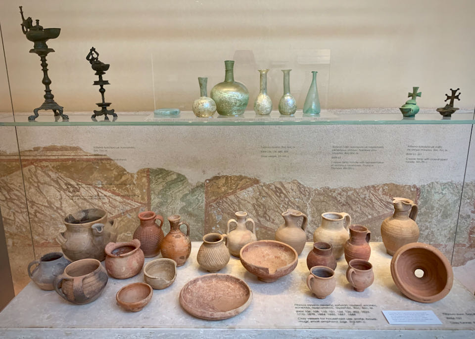 Clay and bronze artifacts on display in a museum case