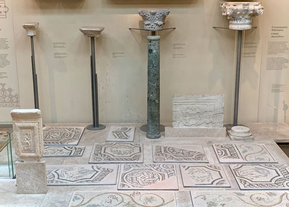 Ancent marble pillars displayed next to mosaic artwork