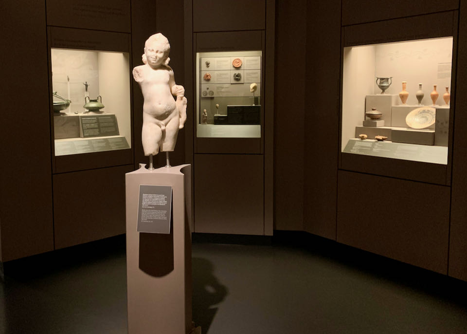 White statue of a young girl on display in a museum