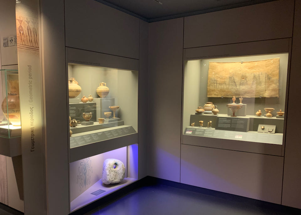 Corner of a museum with display cases filled with early terra cotta vessels