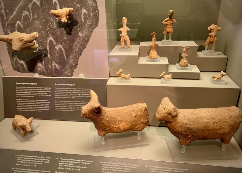 Early clay figures of cattle and humans in a glass display