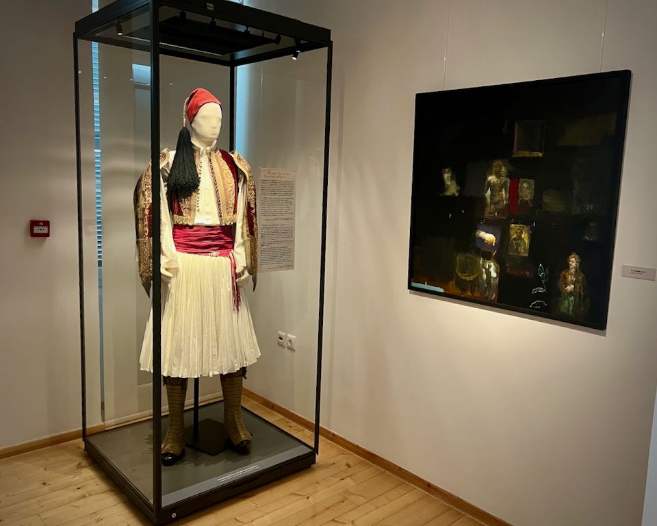 Traditional Greek military costume displayed on a mannequin in a glass case