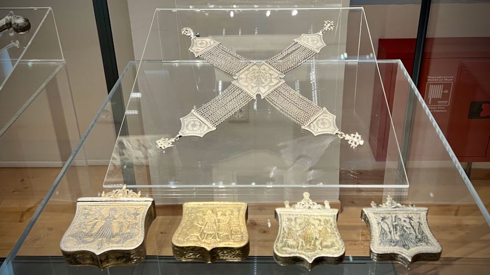 Decorative metal items displayed in a museum case