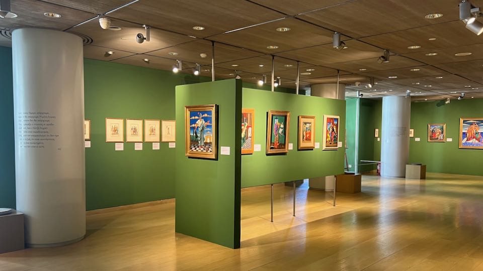 Art gallery with vibrant green walls, hung with colorful paintings