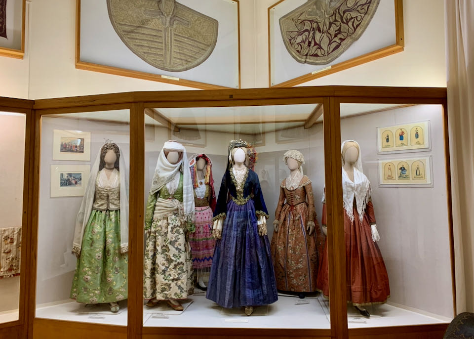 Traditional Greek clothing on display in museum cases