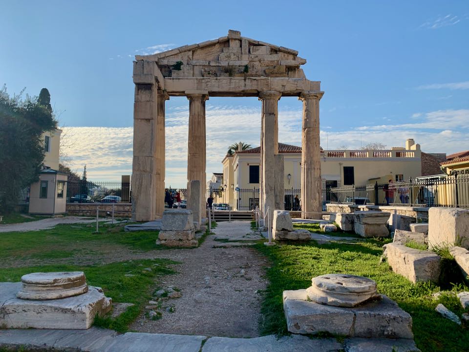 View from inside of the Roman Agora in Athens, looking out through the ruins of a marble portico.