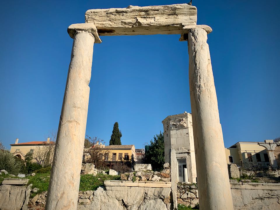Ancient ruins of a simple marble entrance gate in front of a blue sky