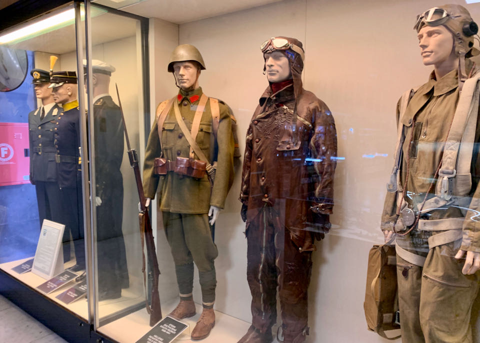 Greek military uniforms on mannequins in museum display cases