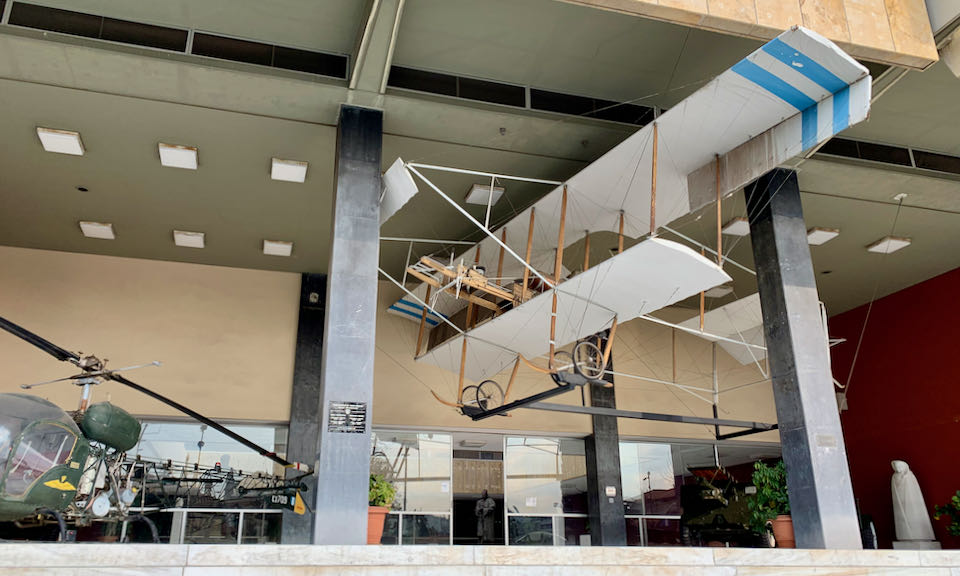 Antique bi-wing plane suspended in display at a museum