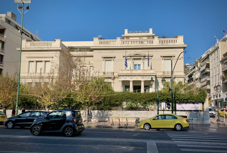 Exterior of a neoclassical style mansion on a busy urban street
