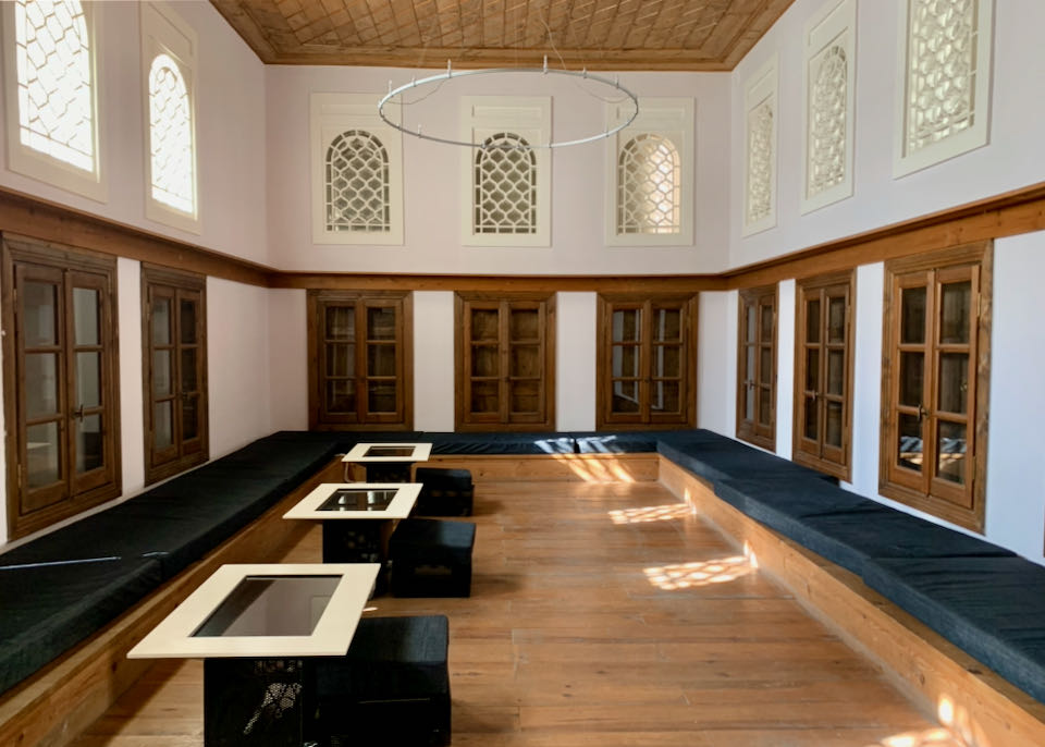 Rectangular room with built-in wooden couches and domed windows
