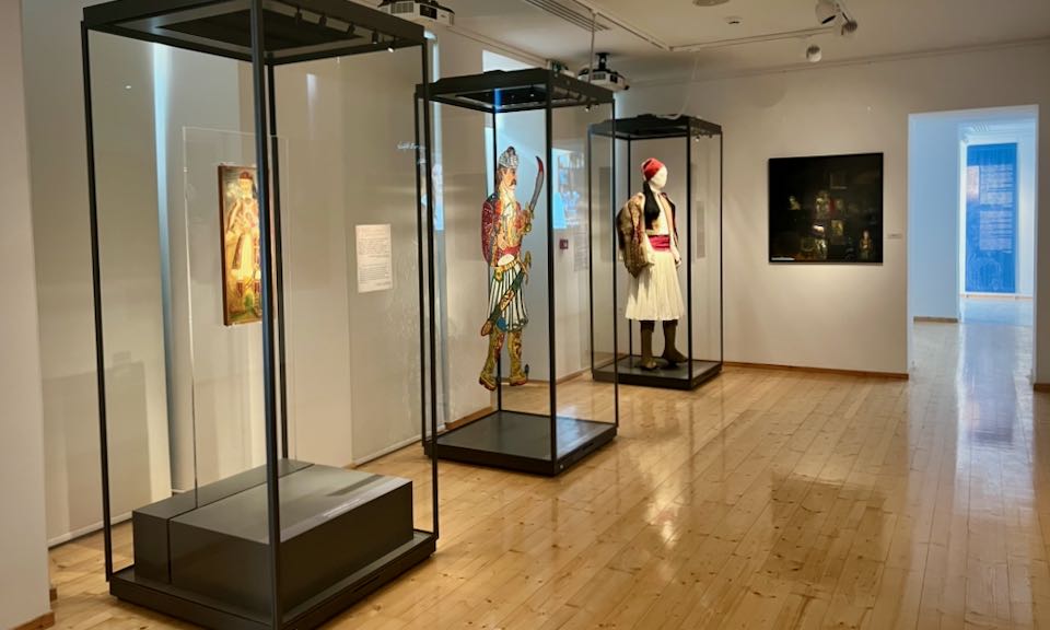 Three glass display cases with elements of traditional Greek costume inside