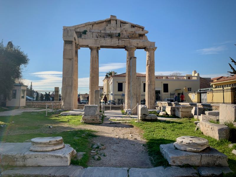 Ancient portico with doric columns, surrounded by fallen pillars