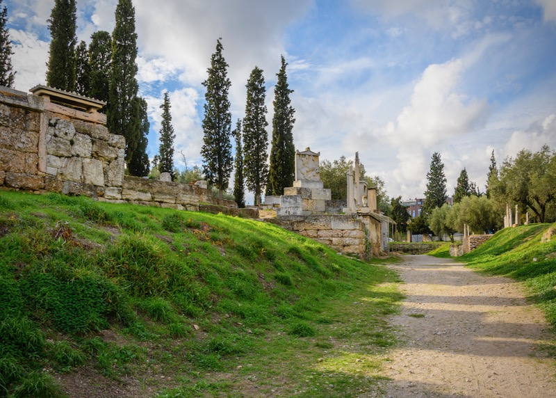 The ancient Sacred Way and Street of the Tombs, the road from Athens to Eleusis, in the ruins of Kerameikos, the Athenian cemetery, in Athens, Greece, with the monument to Dionysis in view.