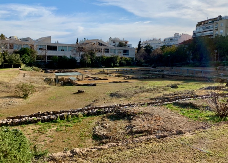 A grassy field with areas dug up for an archaeological excavation