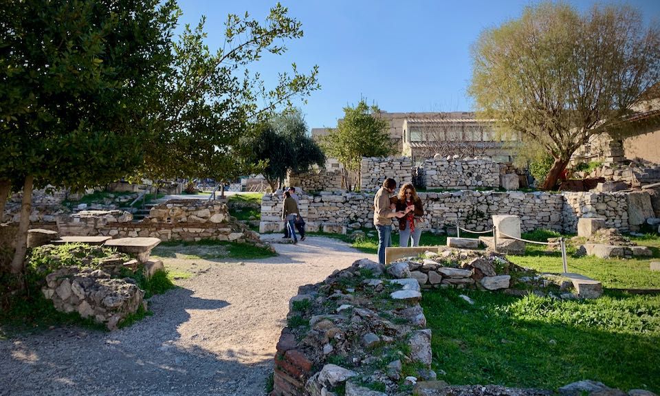 Two people read a sign at an archaeological site.