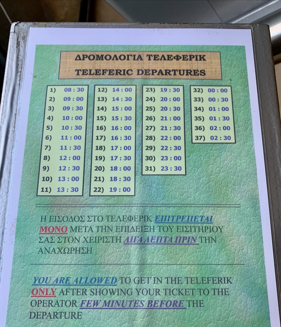 Green poster showing the schedule of cable car departures.