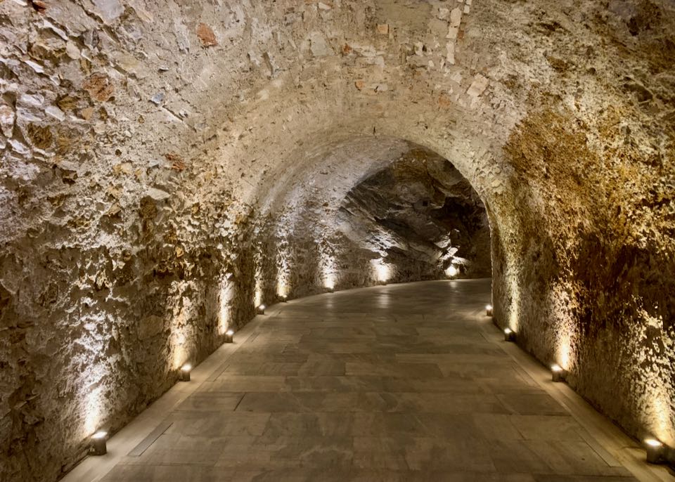 Marble-lined stone tunnel, curving at the end.