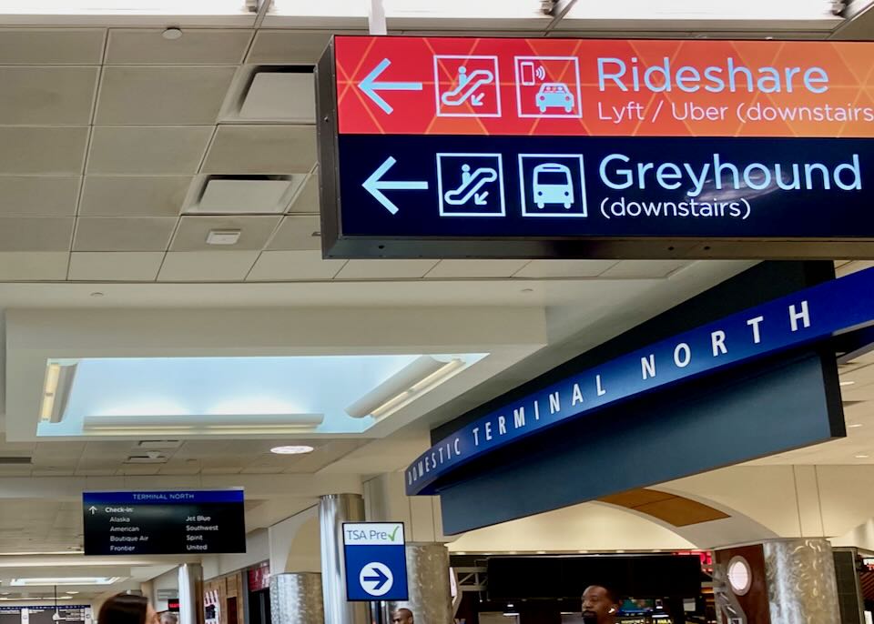 A sign inside the airport points left toward Greyhound.