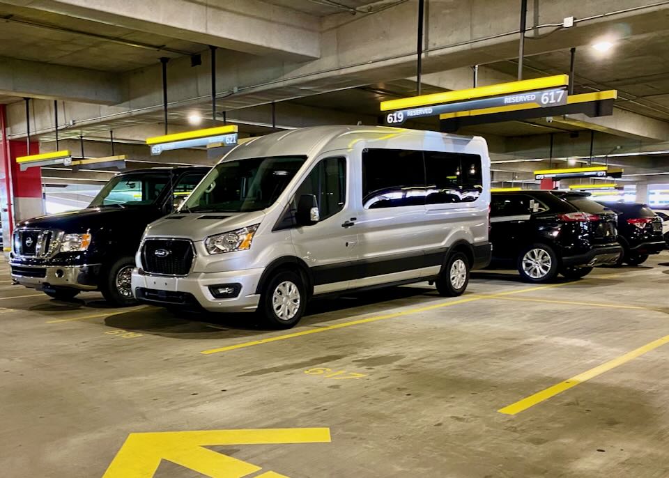 Passenage van parked in the Hertz section of the garage.