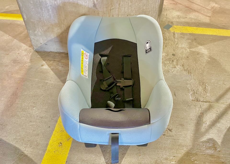 Car seat sitting on the floor of the garage.