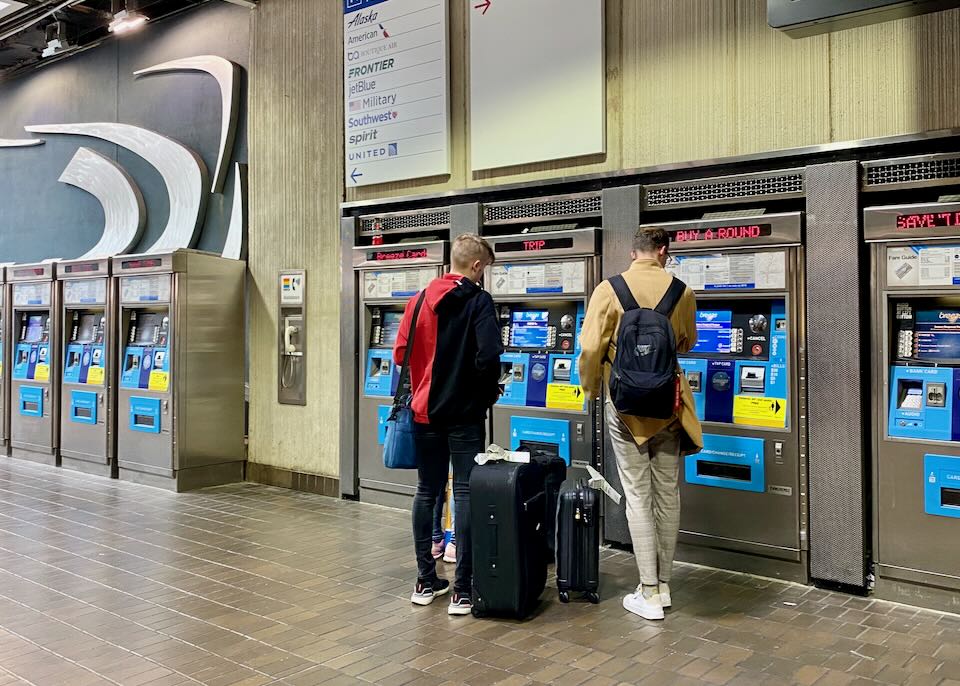 Two men buy a ticket for the MARTA train at a kiosk.