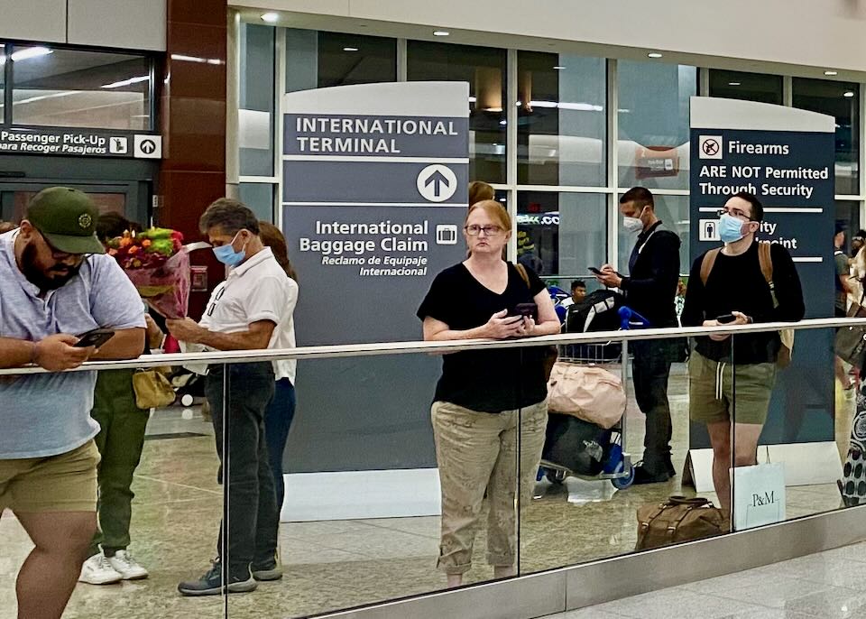 International passengers wait for their luggage at baggage claim.