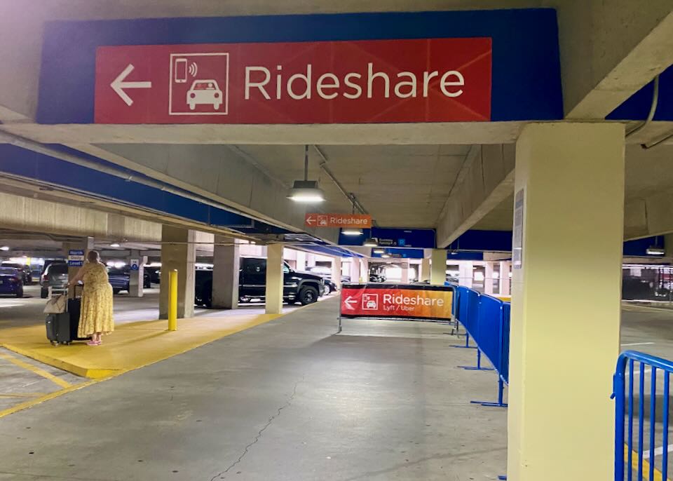 A red Rideshare sign is painted on the parking garage wall with an arrow pointing left.