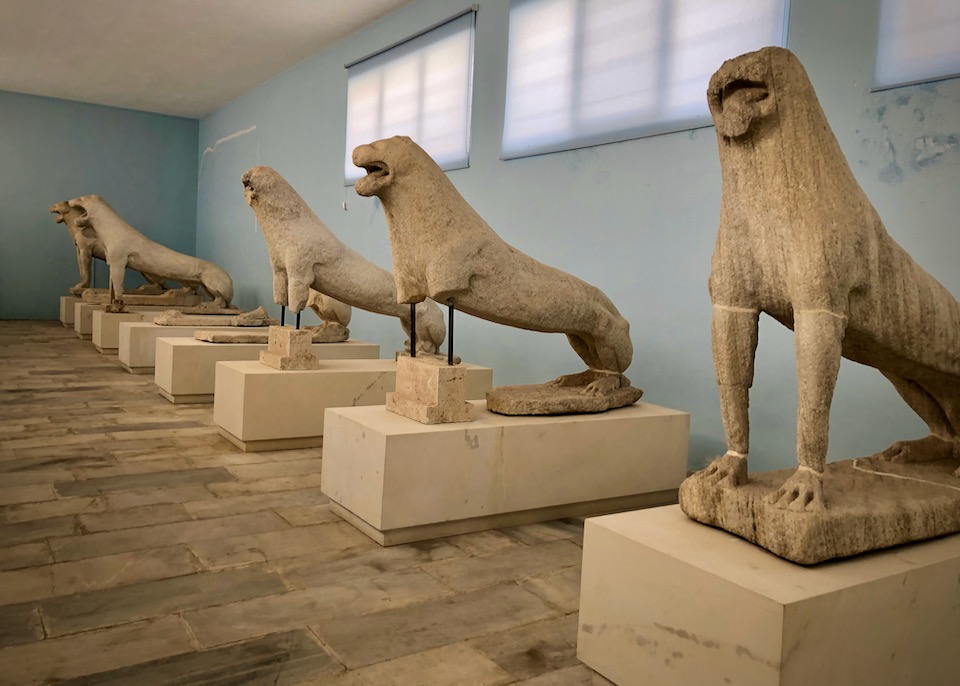 Weathered stone lion statues on display in a museum gallery