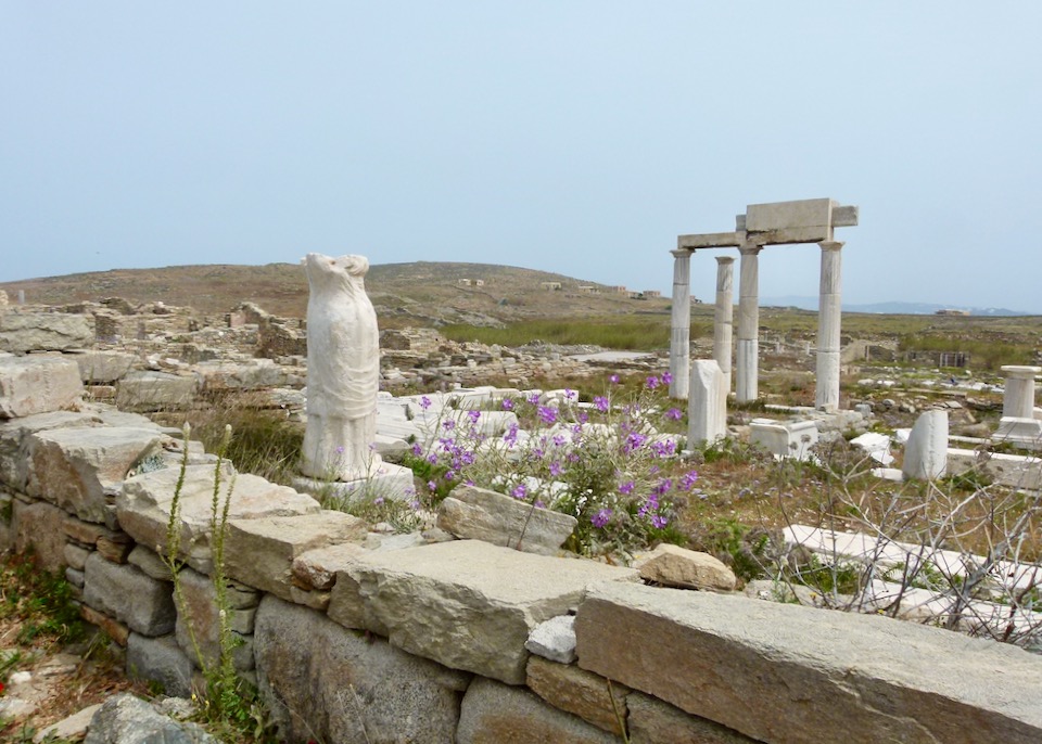 Ancient stone pillars and ruins of a marble statue of a woman