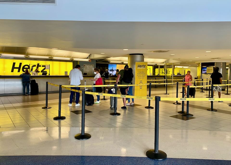 People line up at the Hertz counter.