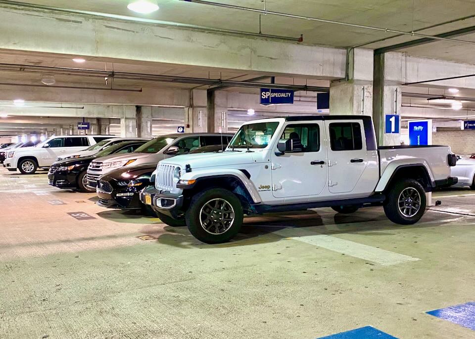 A white jeep sits in the thrifty area of the garage.