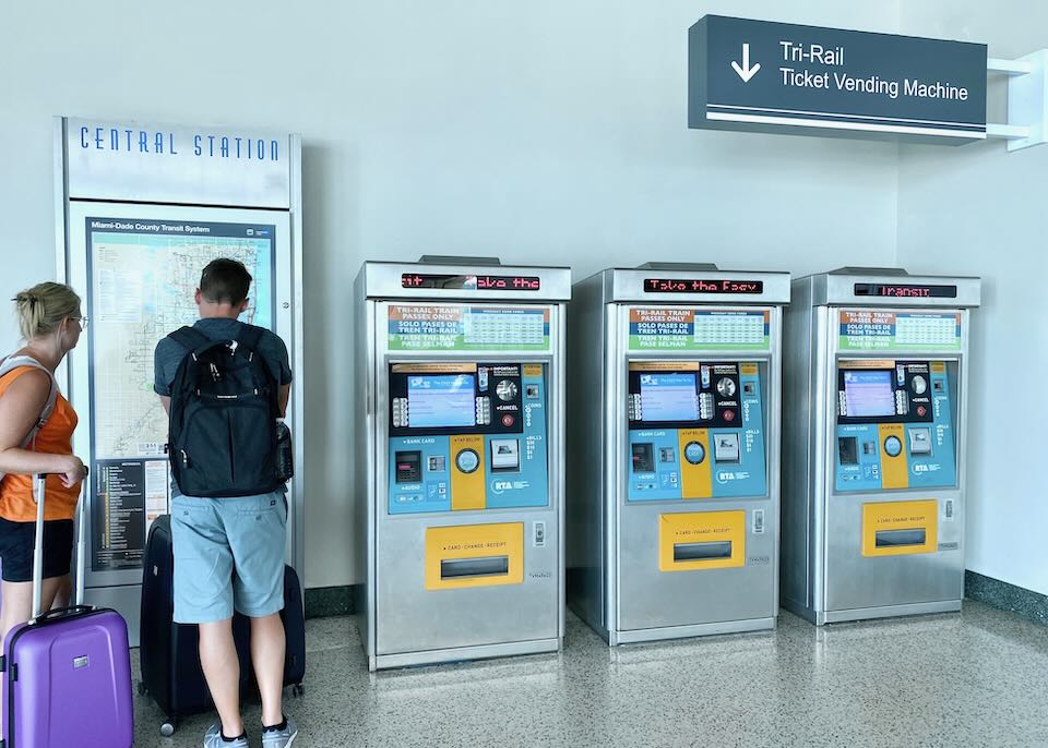 People study the map by the Tri-Rail Ticket Vending Machines.
