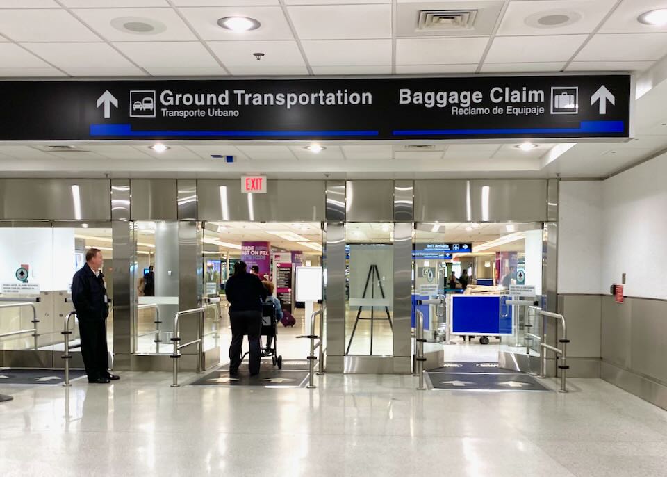 People walk through the doors to baggage claim and ground transportation.