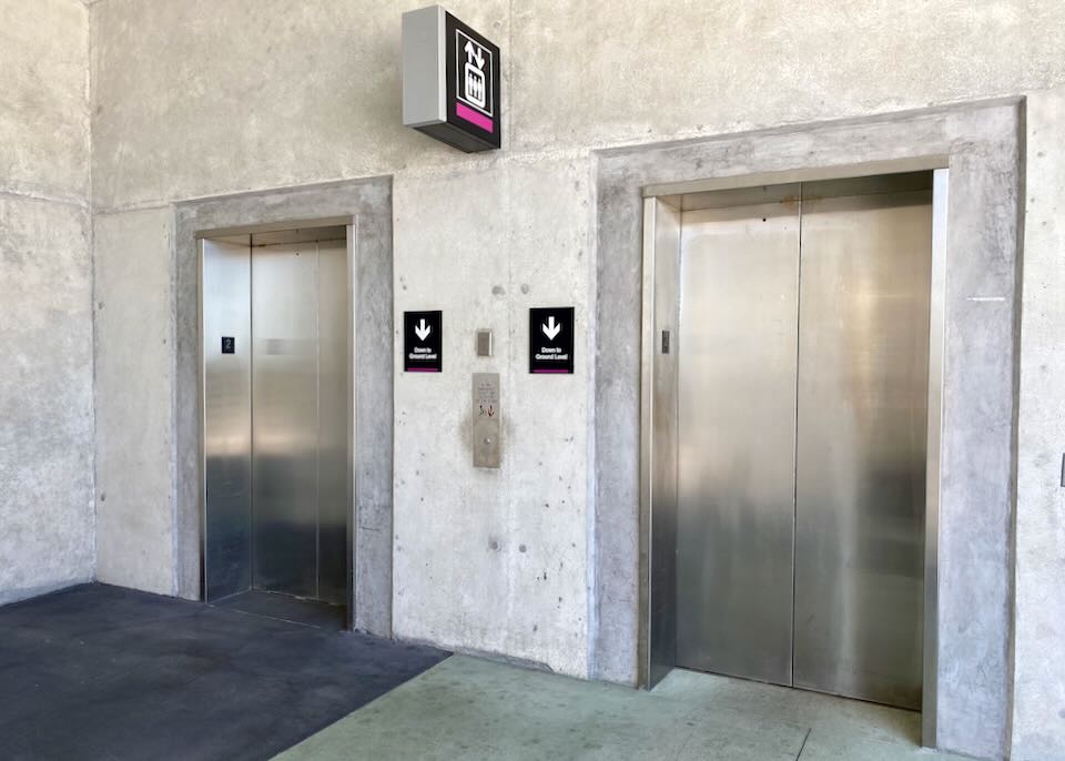 Elevator signs point down to the buses.