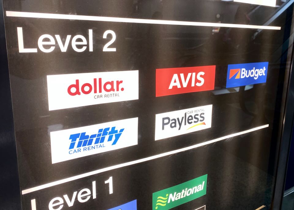 A sign shows level two has Dollar, Avis, Budget, Thrifty, and Payless rental car agencies.