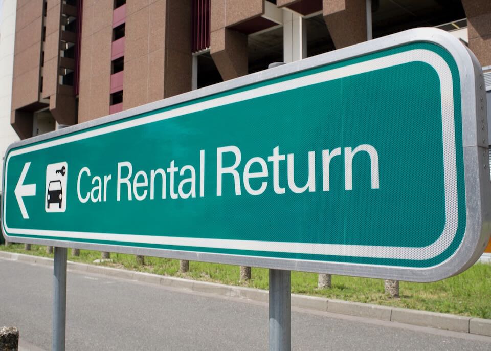 A green sign reads, Car Rental Return.