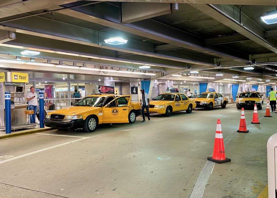Taxis line up on the street outside baggage claim.