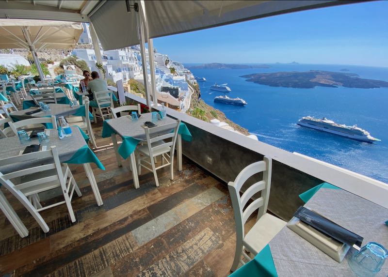 Santorini restaurant with caldera and volcano view.