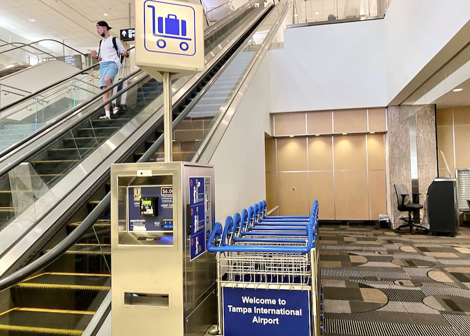 Luggage cart rentals sit at the bottom of the escalator to Baggage Claim.